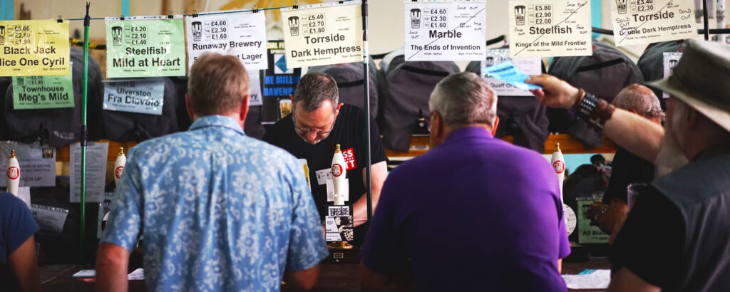 A busy stand at Camra beer festival, with customers in a line ordering beer